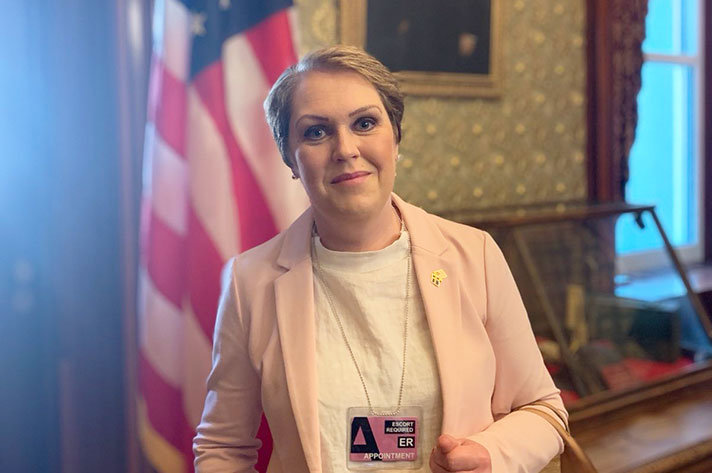 Lena Hallengren stands in front of an American flag.