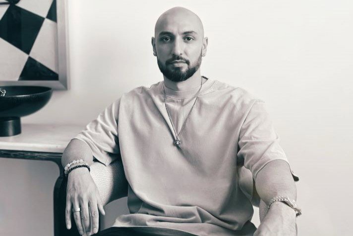 Ilya Salmanzadeh sitting in a chair, looking into the camera.