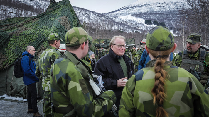 Peter Hultqvist standing outside surrounded by soldiers.