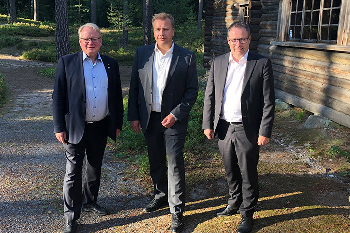 From the left: Peter Hultqvist, Antti Kaikkonen and Bjørn Arild Gram standing next to each other outside  in a forrest. 