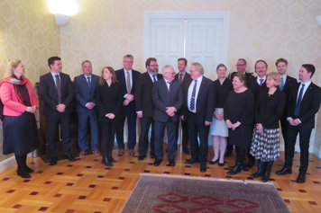 Peter Hultqvist standing inside surrounded by ambassadors.