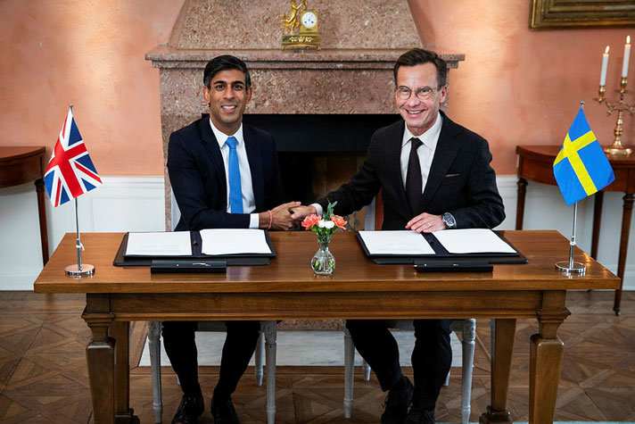 Prime Minister Ulf Kristersson and British Prime Minister Rishi Sunak behind a desk after signing the document.
