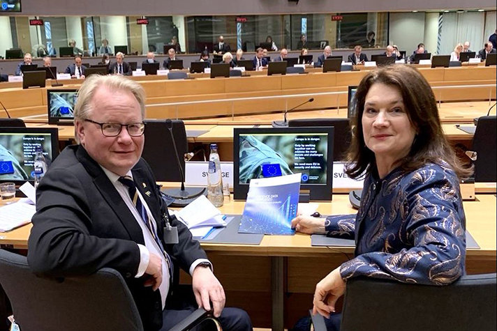 Peter Hultqvist (to the left) and Ann Linde (to the right) sitting next to each other looking into the camera.