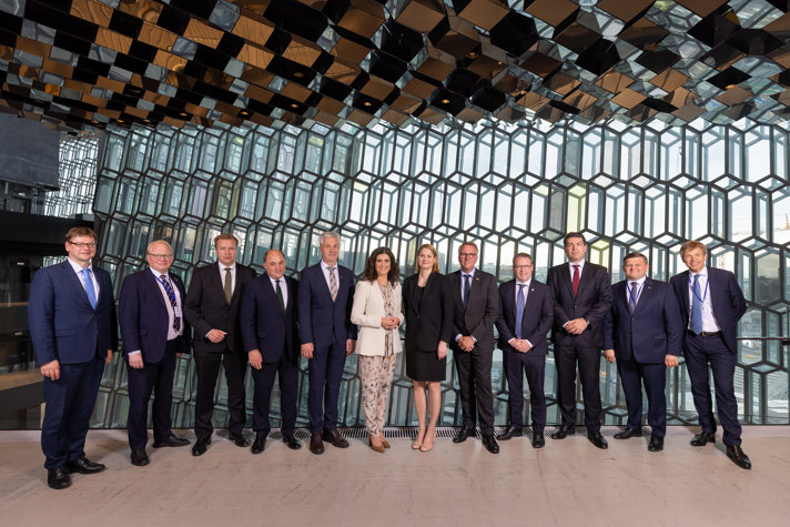 The ministers standing inside in front of a glass wall.