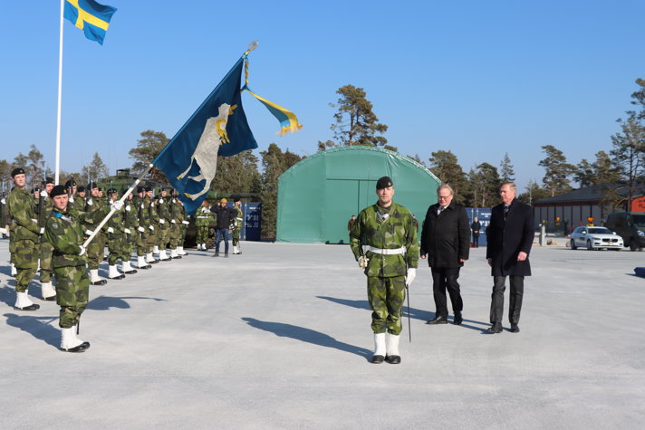 Mr Hultqvist and Mr Laanet walking outside greated by soldiers.