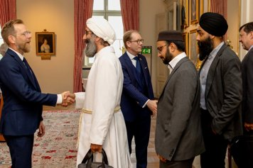 The ministers shake hands with representants from faith communities