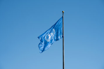 UN flag against sky.