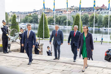 The four ministers walking up the stairs leading to the palace.
