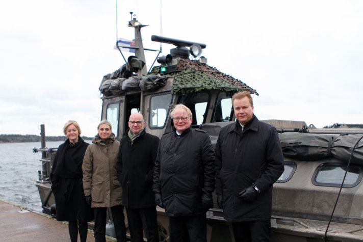 The participating ministers standing outside in front of a ship.