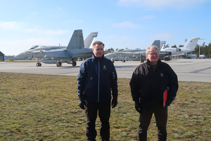 Swedish Minister for Defence Peter Hultqvist and his Finnish counterpart Antti Kaikkonen standing outside with airplanes in the background.