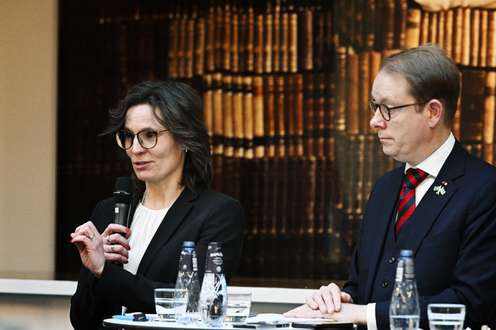Roswall and Billström speaking in a microphone 